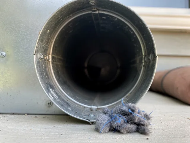 Foxborough Dryer Vent Cleaning technician using specialized equipment to clear severe dryer vent blockage in Foxborough